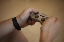 person holding white and black xbox one game controller