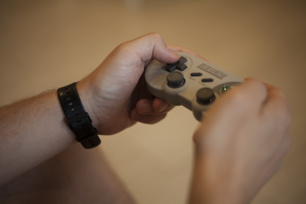 person holding white and black xbox one game controller