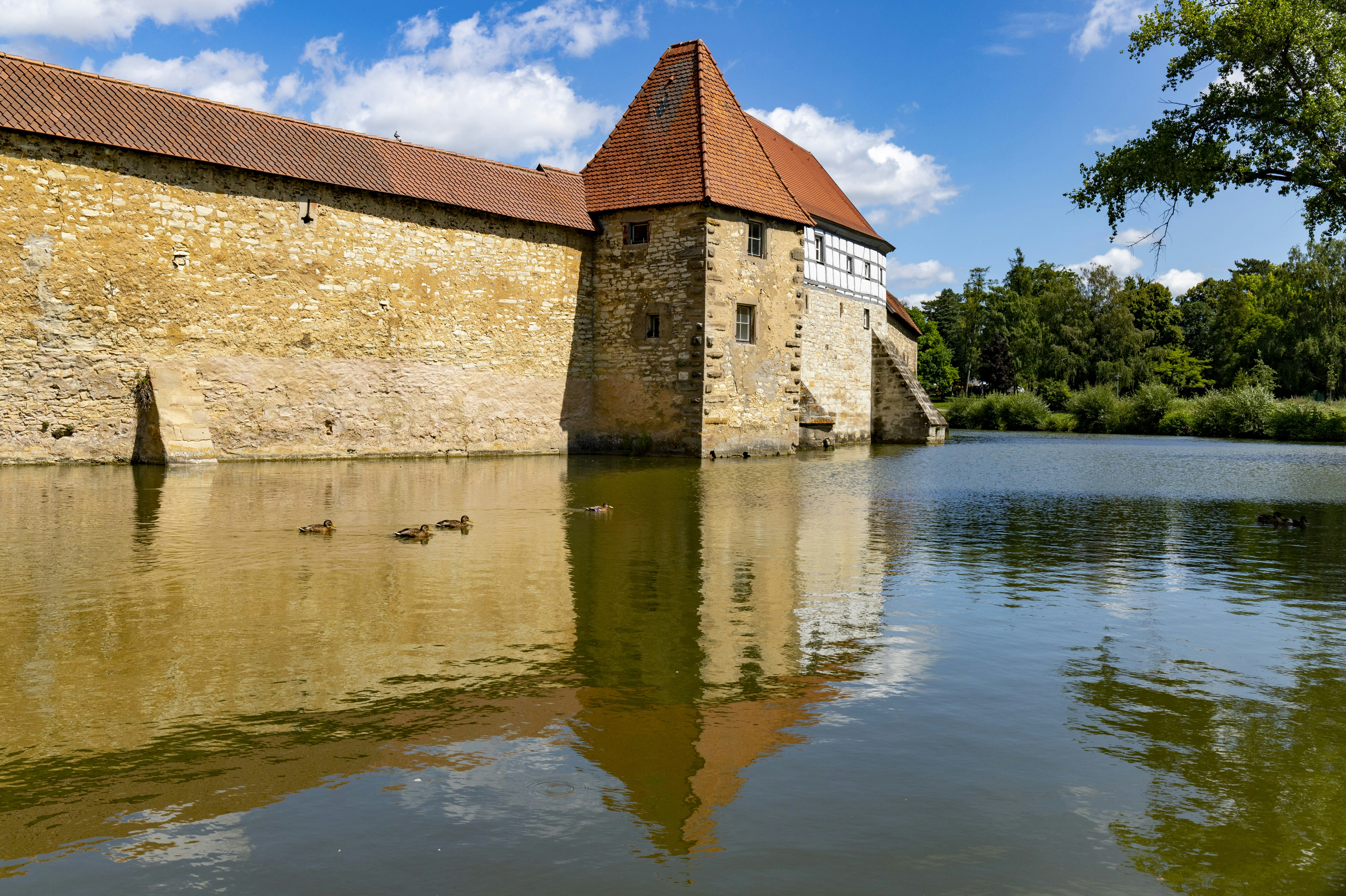 Braunes Betongebäude in der Nähe von Gewässern unter blauem Himmel tagsüber