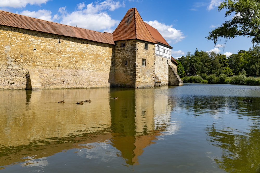 brown concrete building near body of water under blue sky during daytime