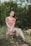woman in red and white floral dress sitting on brown log