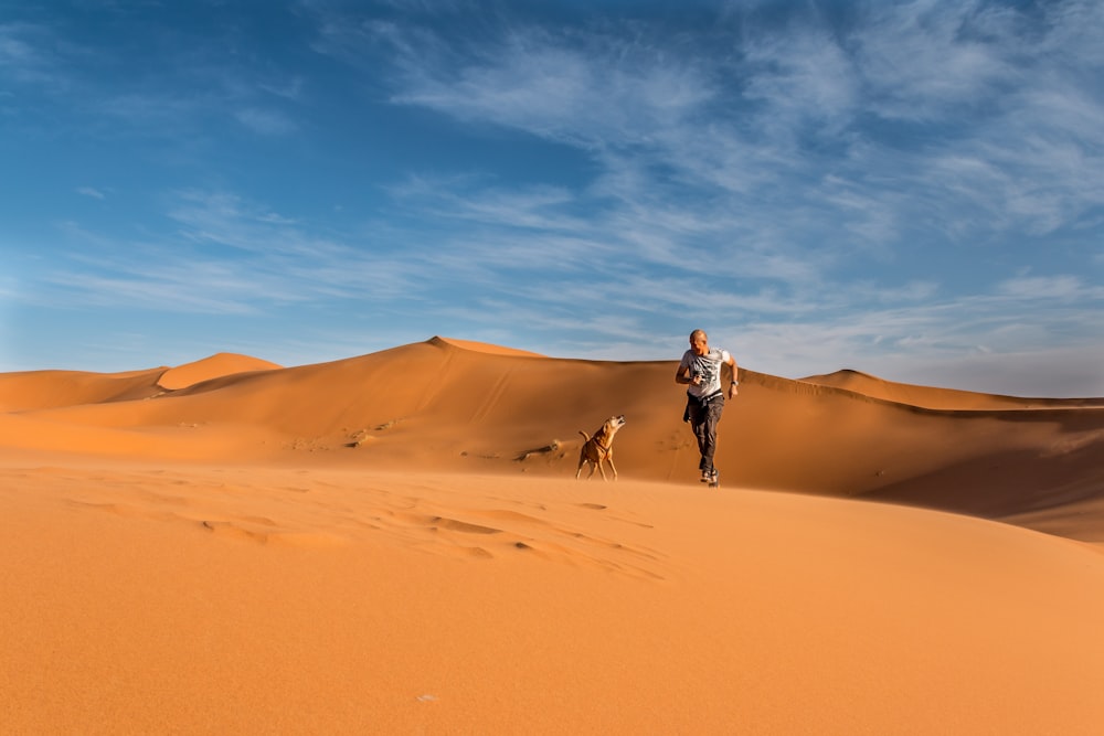 Uomo che cavalca il cammello nel deserto durante il giorno