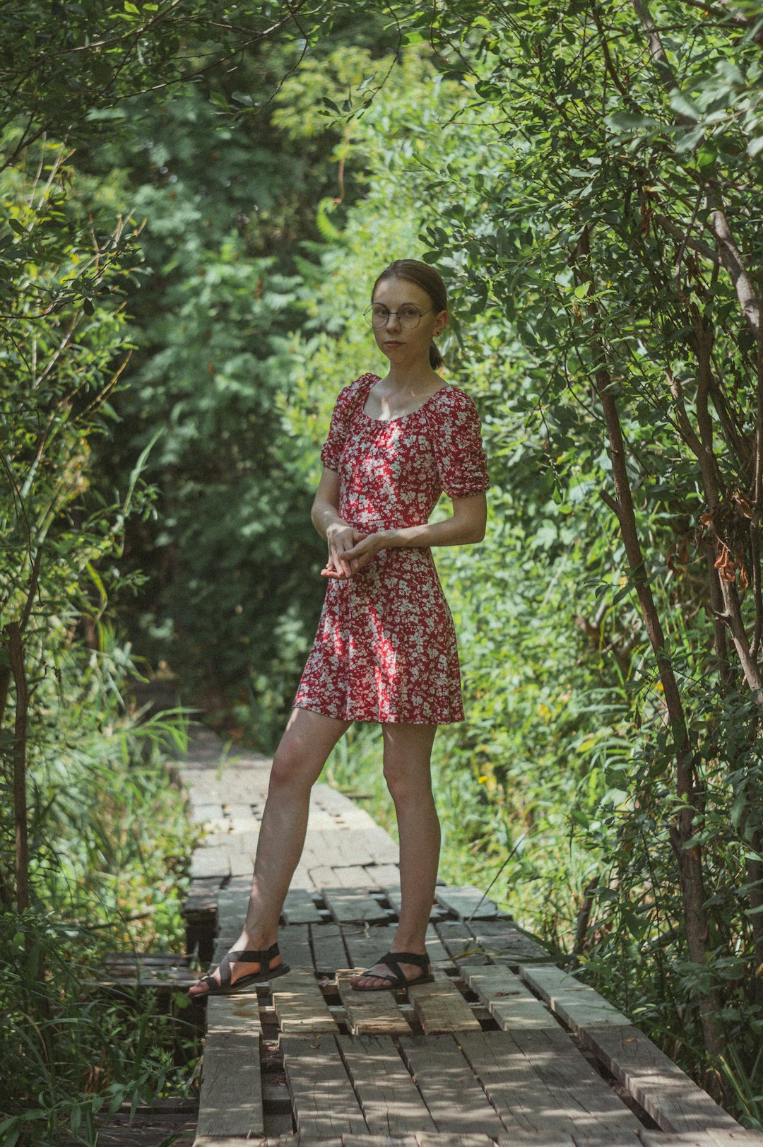 woman in red and white floral dress standing on gray concrete pathway