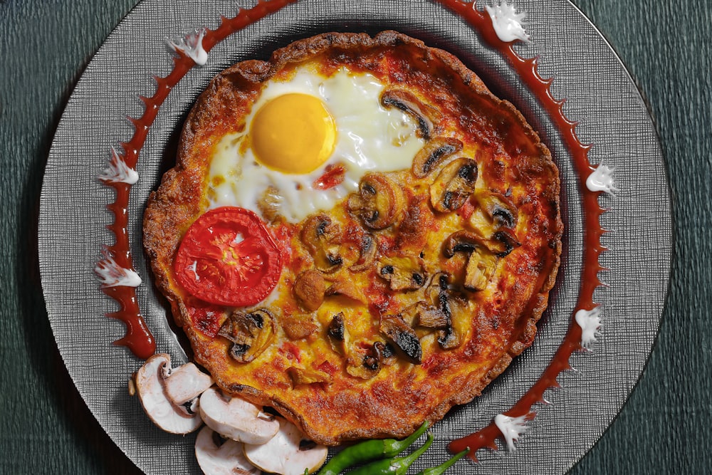 egg and bacon pizza on blue round plate