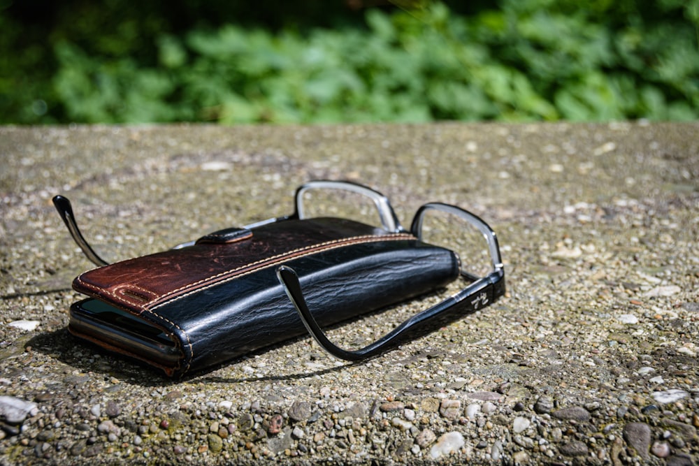 black framed eyeglasses on brown book