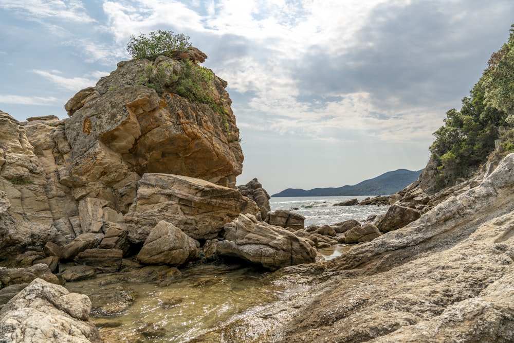 brown rock formation near body of water during daytime