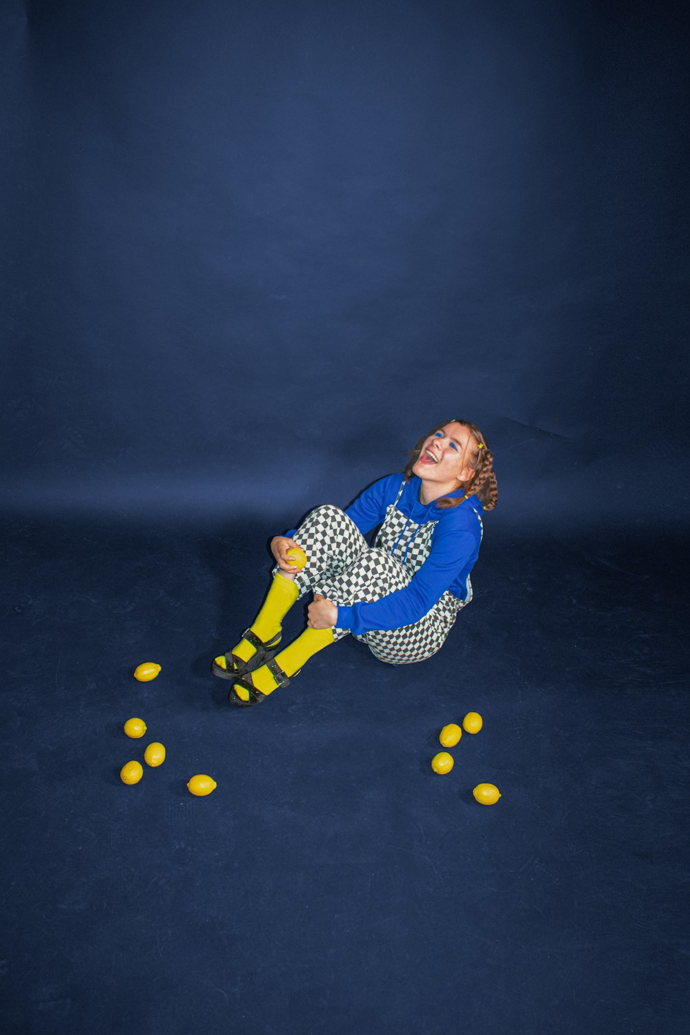 woman in blue and white polka dot dress sitting on black floor