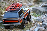 red and black jeep wrangler on dirt road during daytime