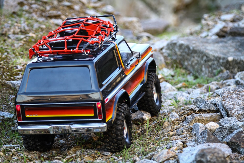 red and black jeep wrangler on dirt road during daytime