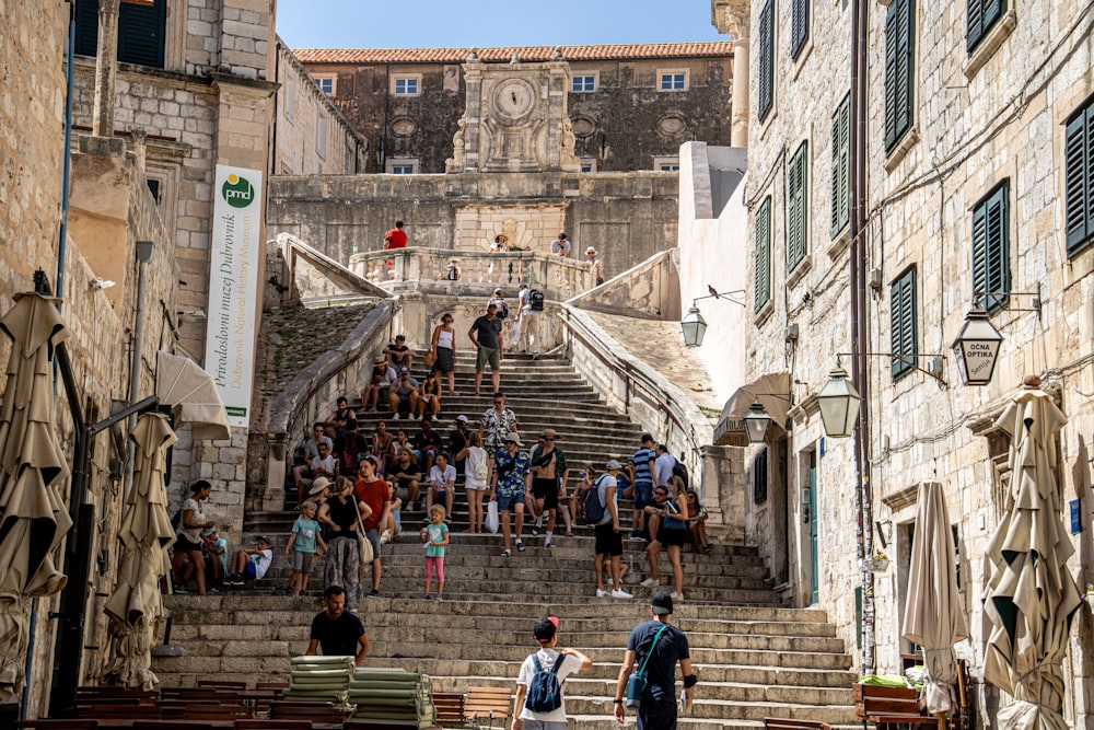 people walking on gray concrete stairs near gray concrete building during daytime