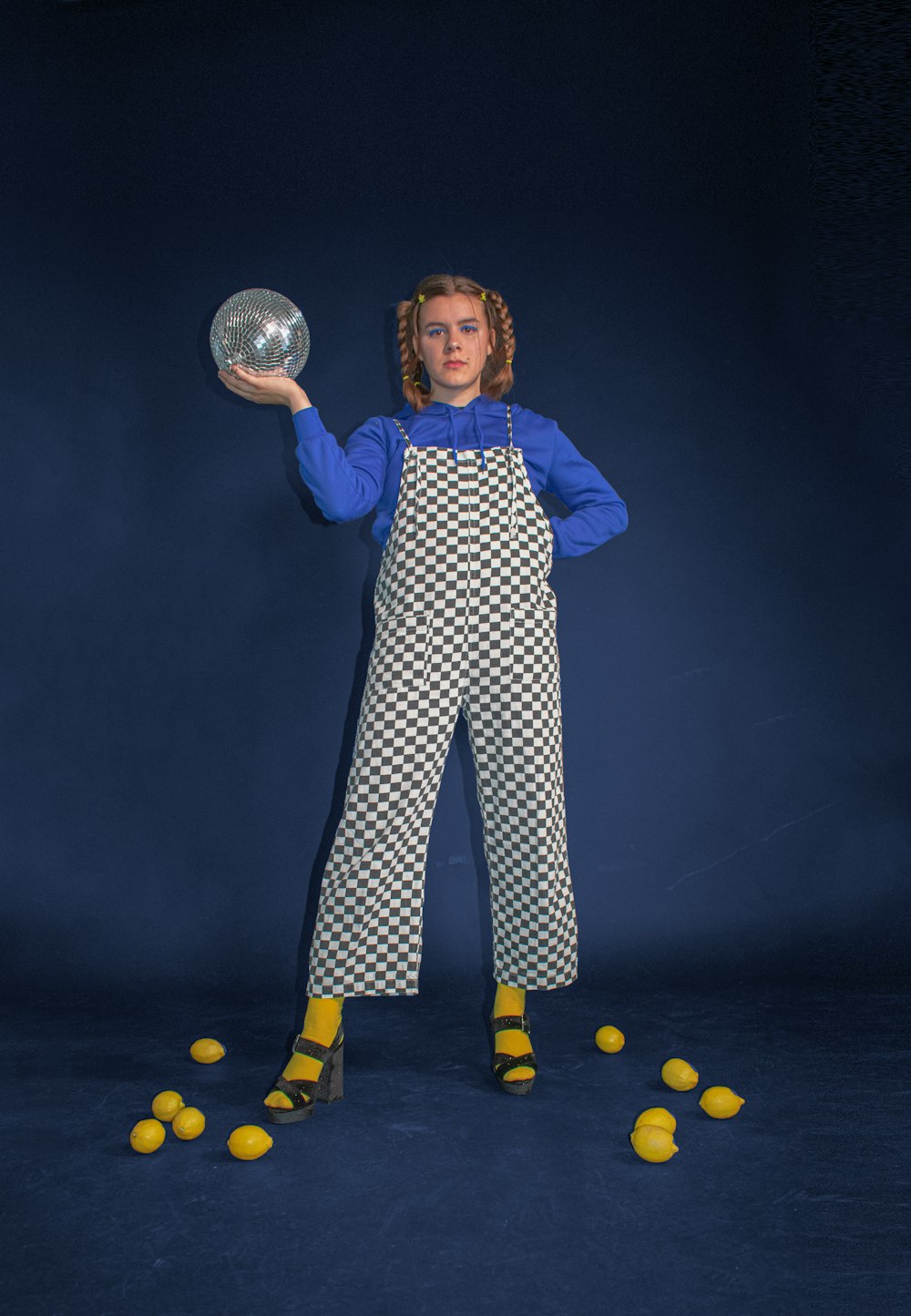 boy in blue and white checkered pajama set holding silver ball