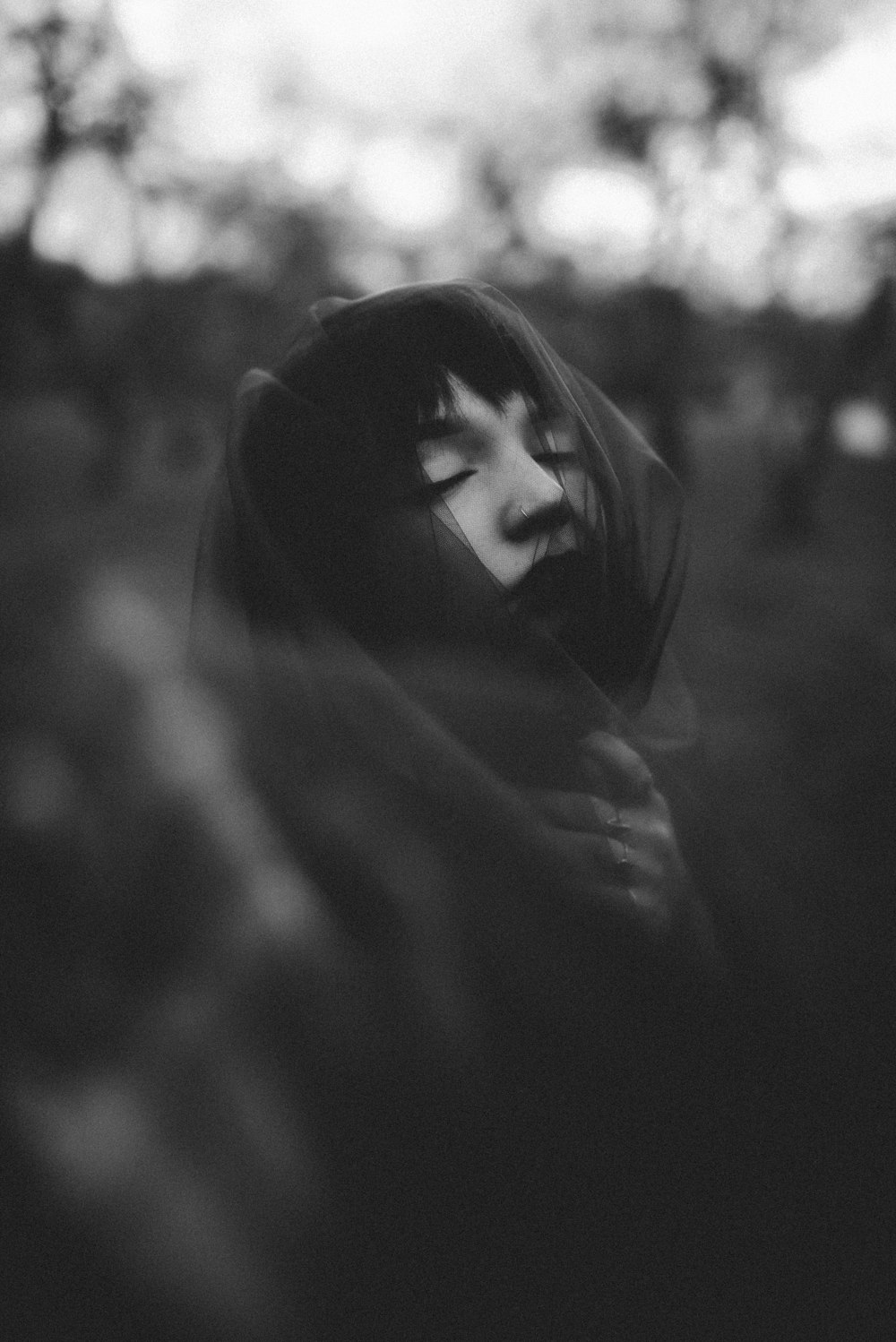 a black and white photo of a person wearing a hood