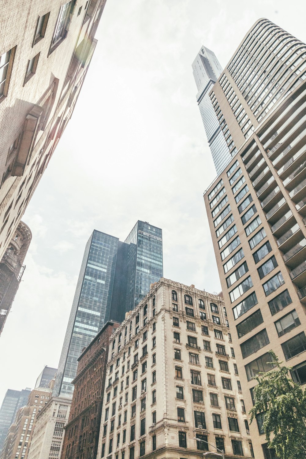 low angle photography of high rise buildings under white sky during daytime