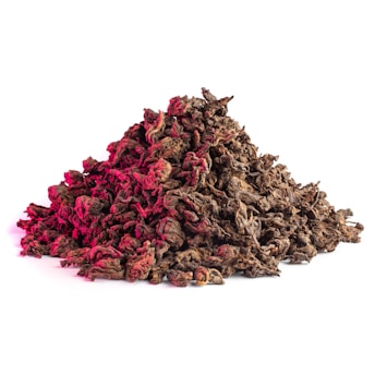 A pile of dried tea leaves with a textured surface, partially highlighted in red light, creating an interesting contrast against the natural brown hues.