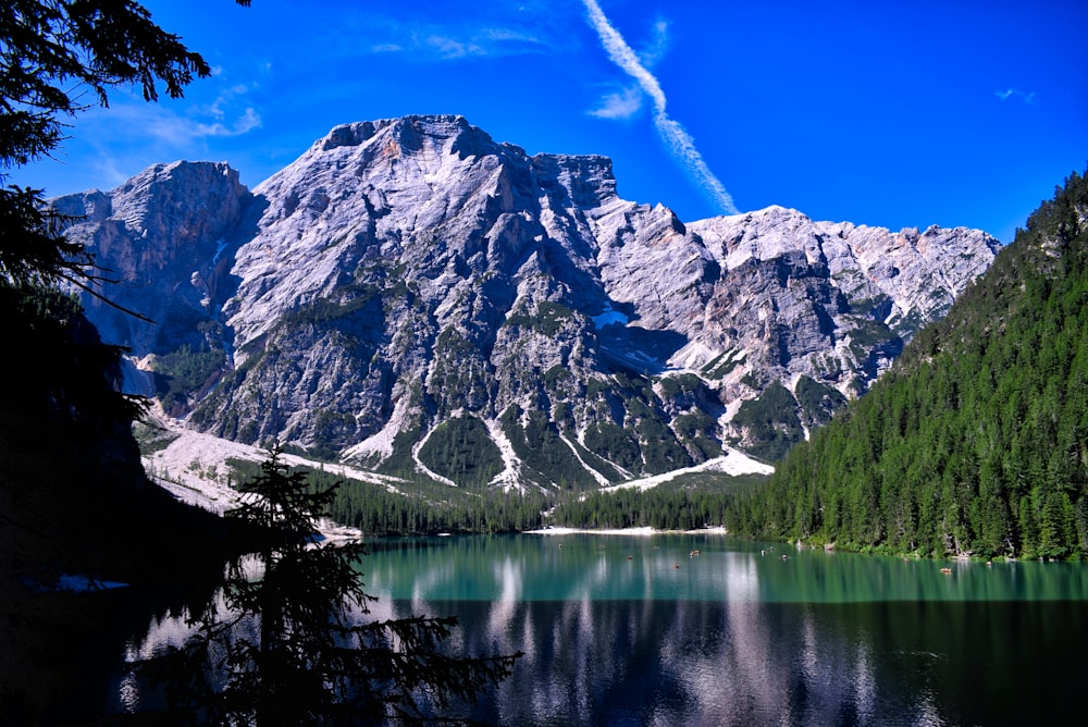 lake near snow covered mountain under blue sky during daytime