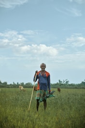 man in red and blue polo shirt standing on green grass field during daytime
