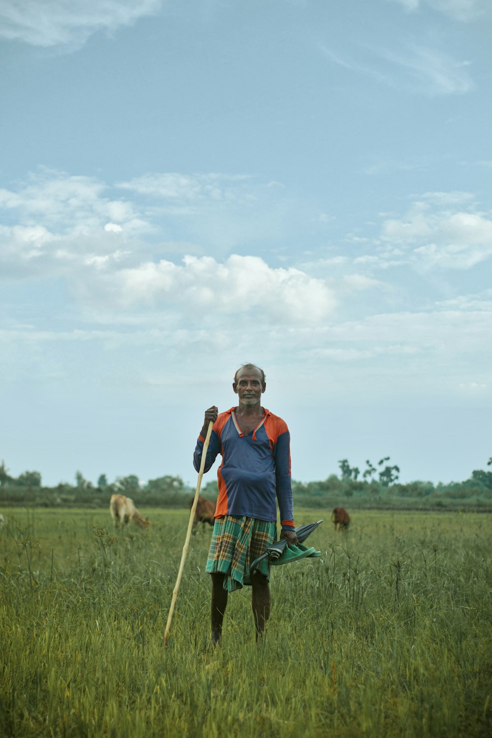 man in red and blue polo shirt standing on green grass field during daytime