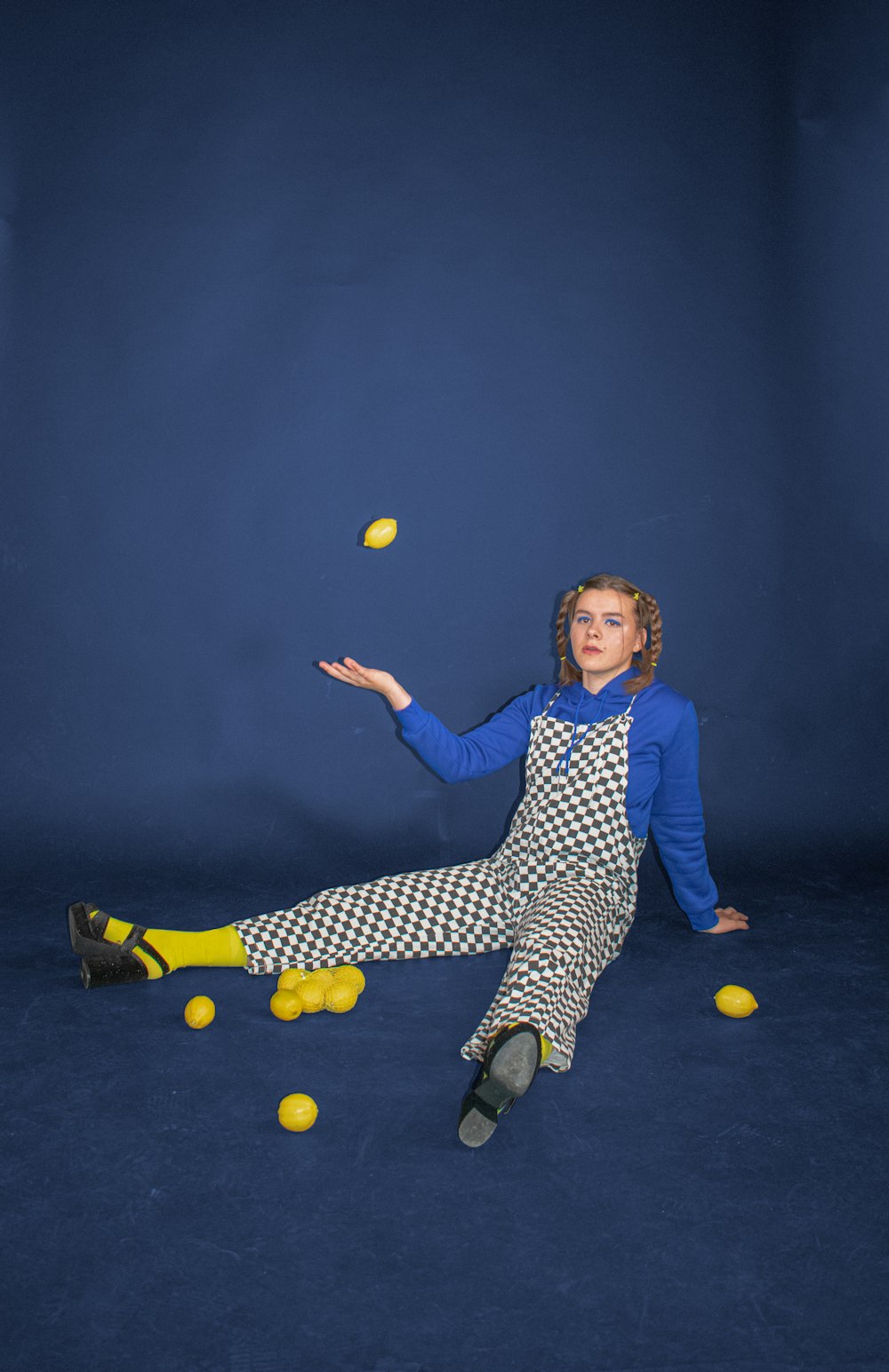 garçon en chemise à manches longues bleue et blanche et pantalon noir et blanc jouant avec le jaune