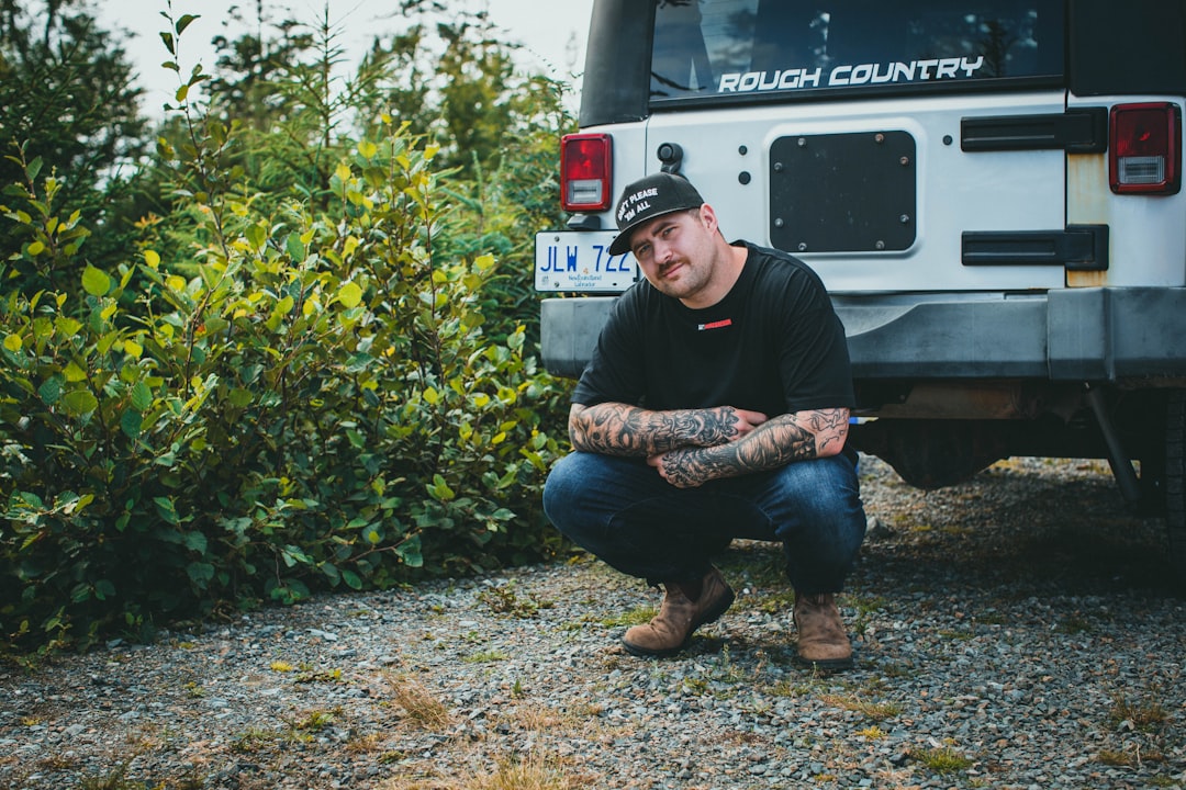 man in black jacket sitting on truck