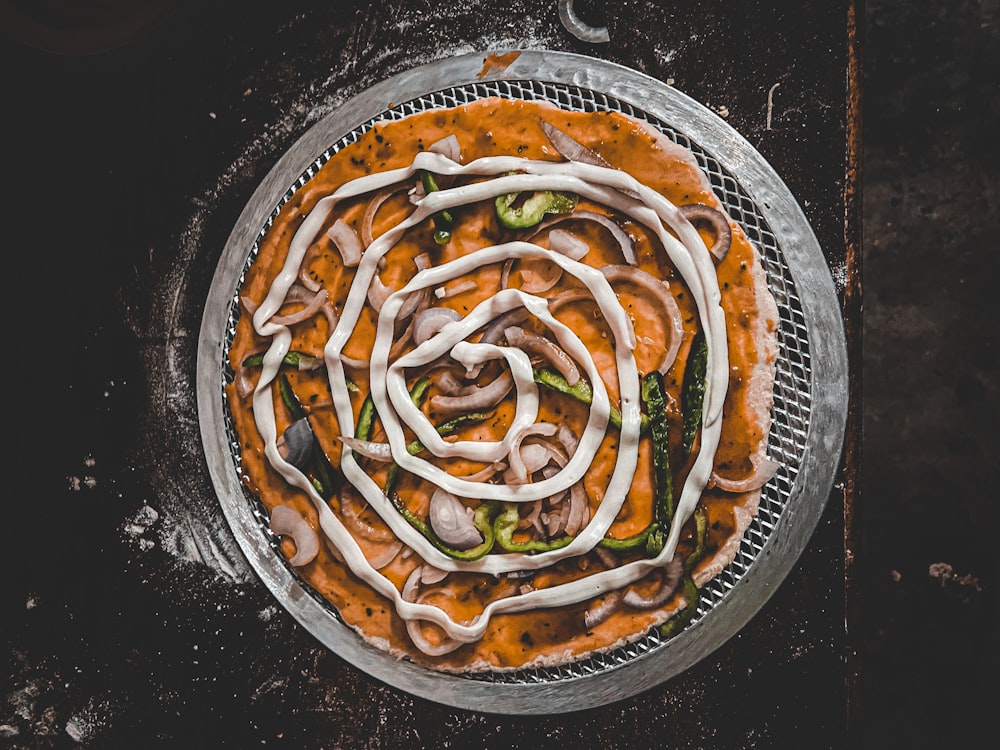 brown and green vegetable dish on black round plate