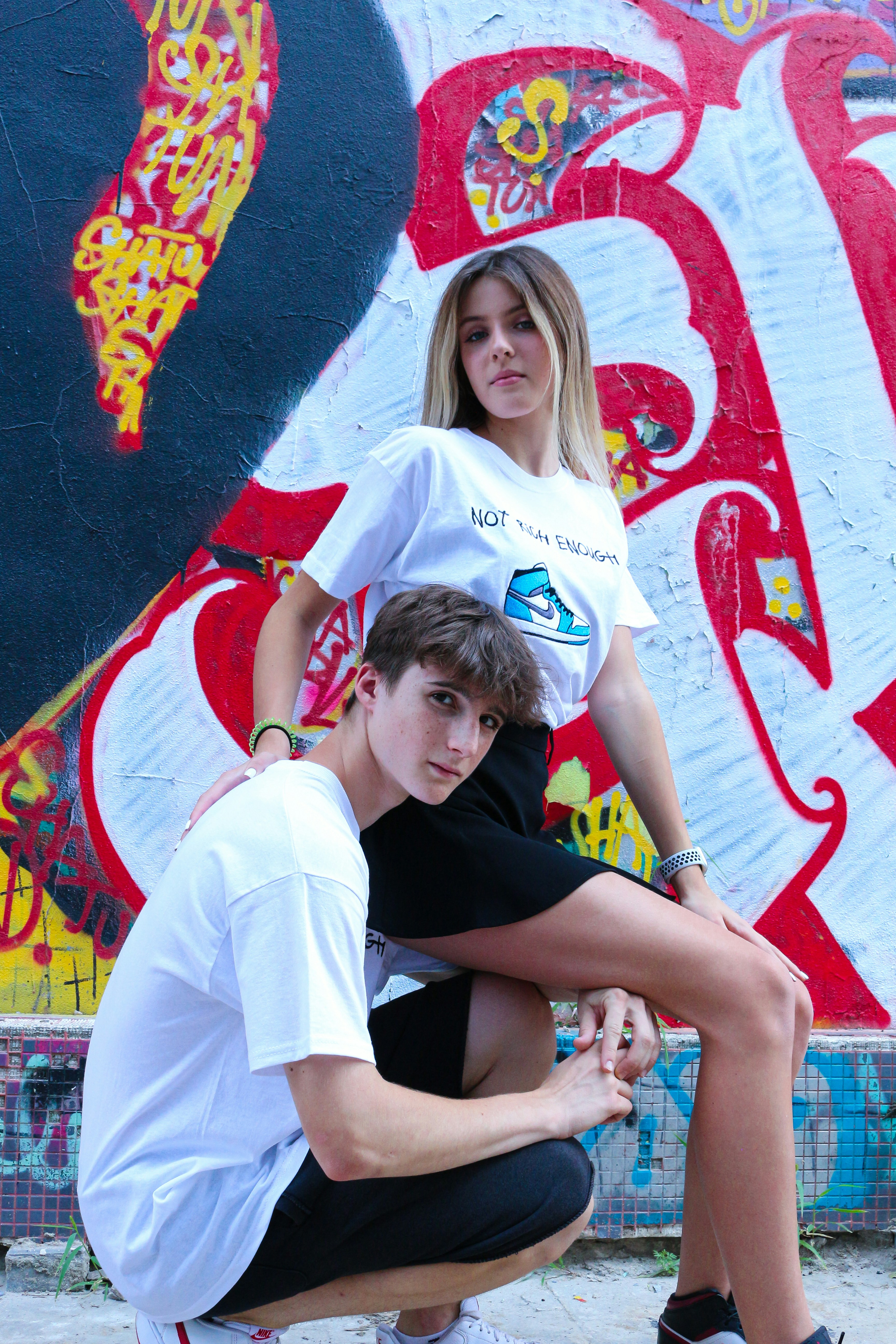 Frau im weißen T-Shirt sitzt neben Frau im schwarzen T-Shirt