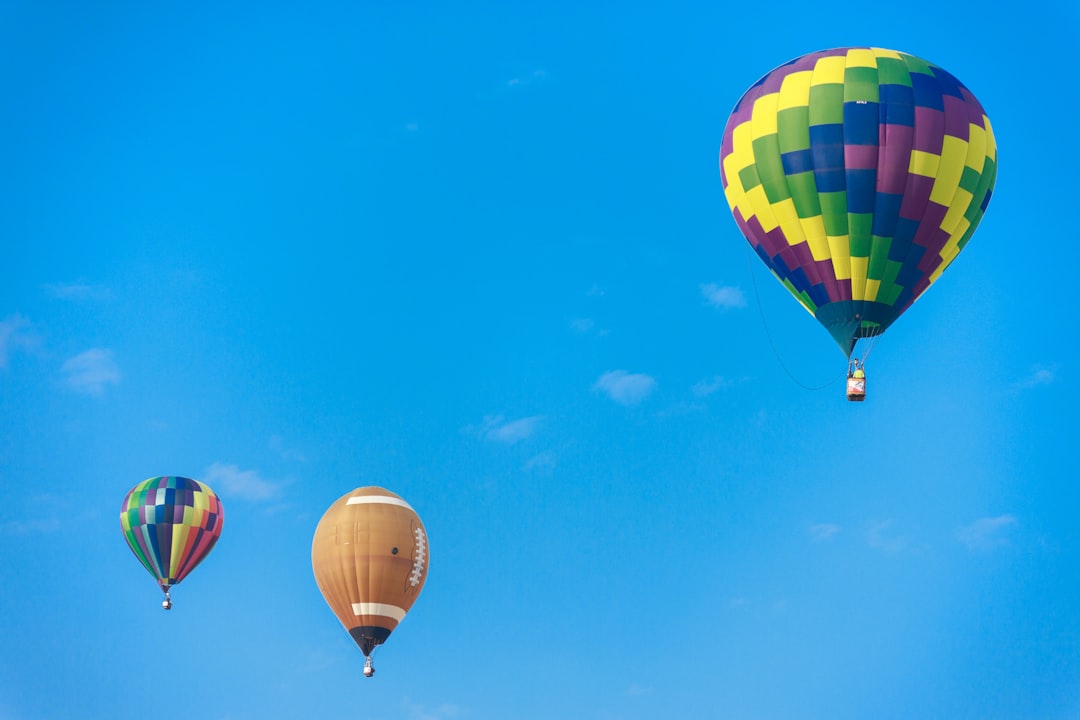 yellow red and blue hot air balloon in mid air under blue sky during daytime