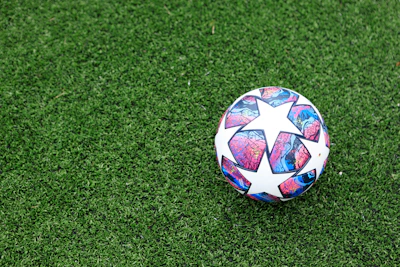 white blue and red soccer ball on green grass