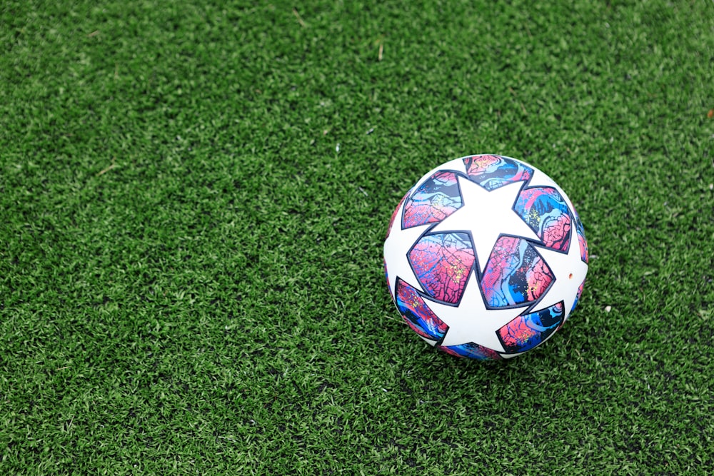 푸른 잔디에 흰색 파란색과 빨간색 축구 공
