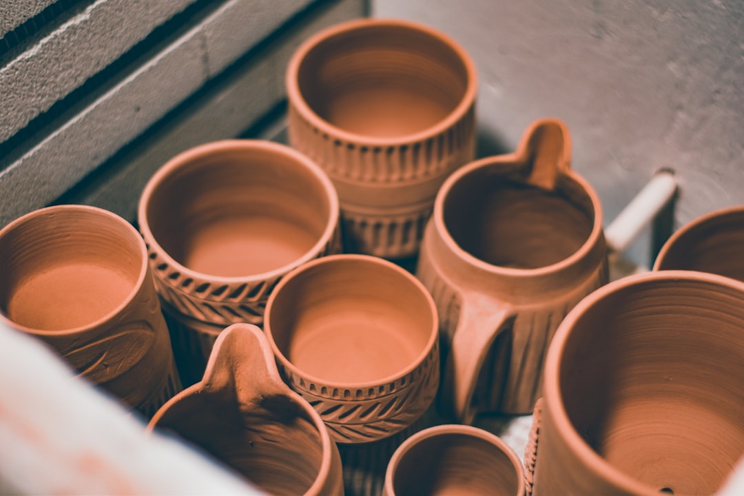 brown ceramic mugs on brown wooden shelf,