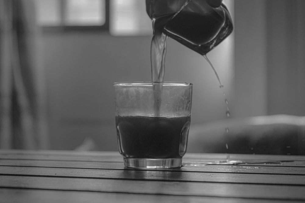 grayscale photo of clear drinking glass with water