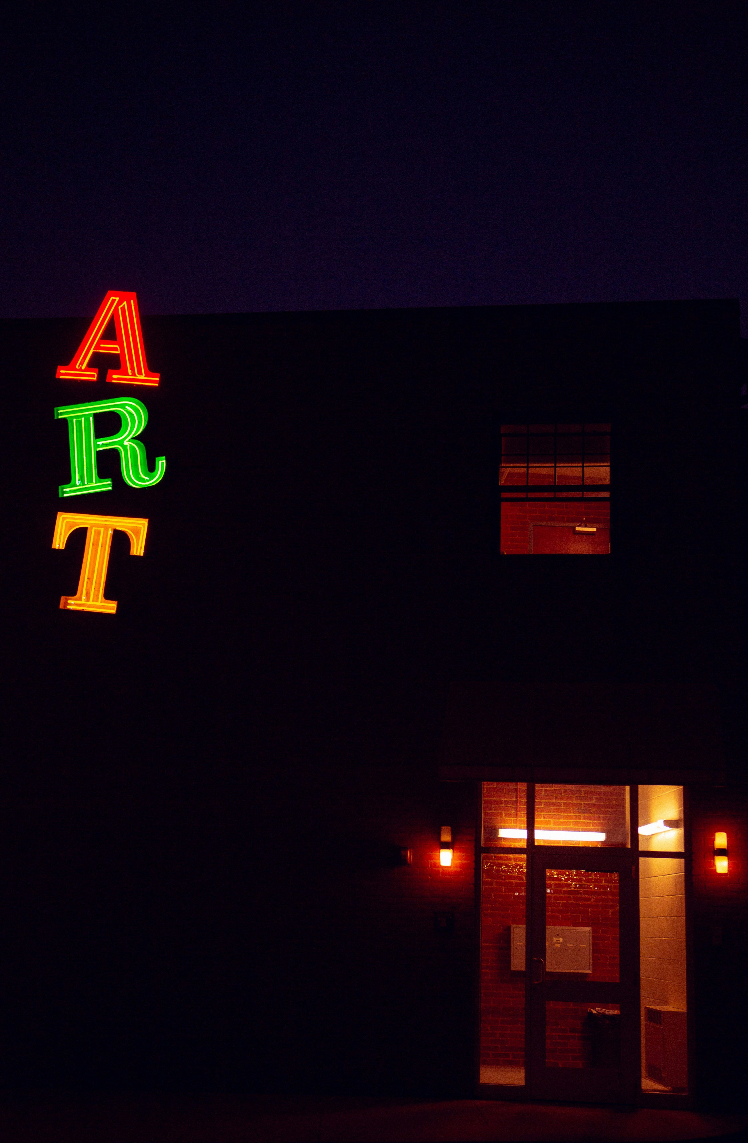 An 'ART' sign casts light on an otherwise dark summer evening. 