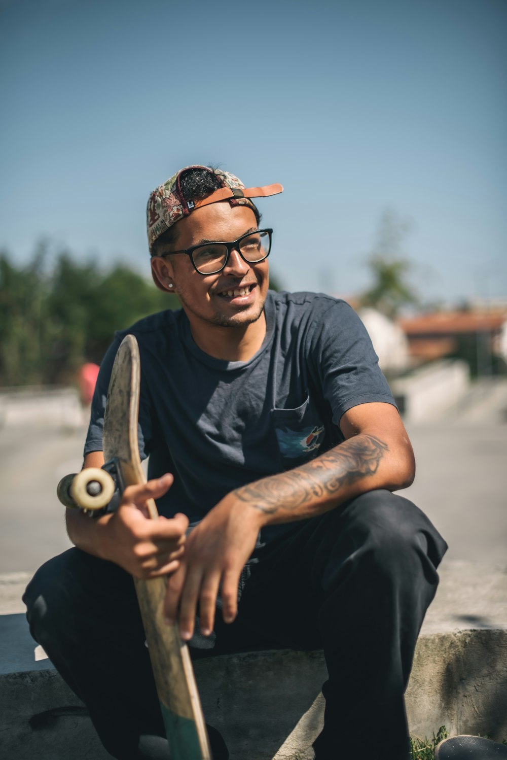 man in black crew neck t-shirt wearing black framed eyeglasses and black pants sitting on on with on with