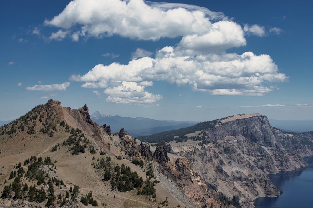 brown and green mountains under blue sky and white clouds during daytime