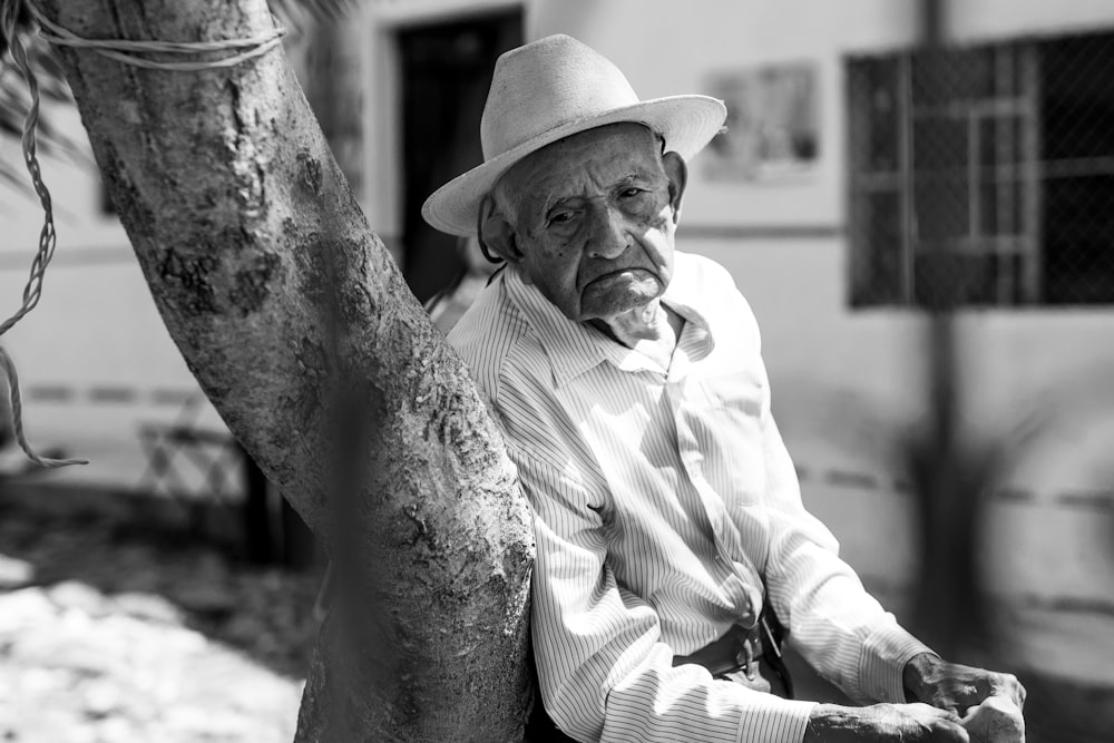 man in white dress shirt and hat sitting on chair