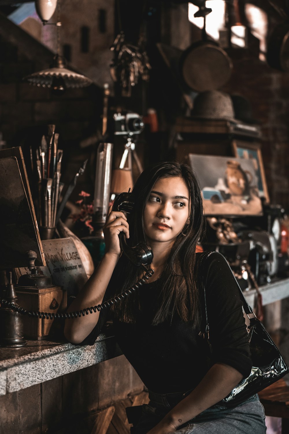 woman in black long sleeve shirt sitting on brown wooden chair