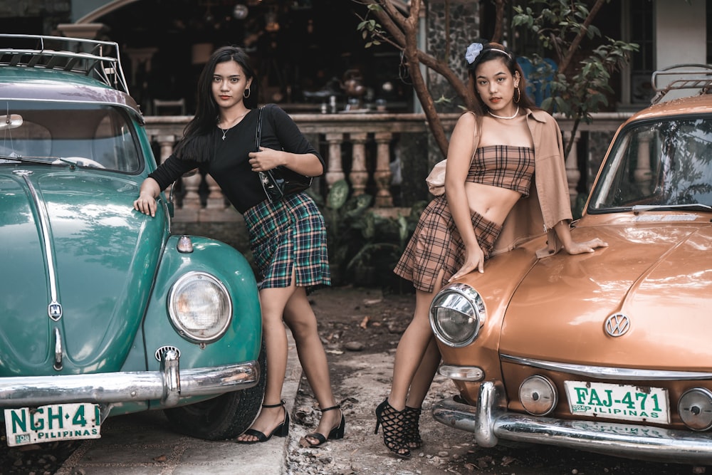 woman in brown sleeveless dress leaning on green car during daytime