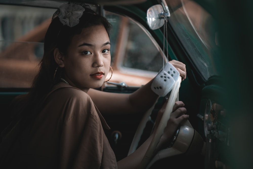 woman in brown shirt driving car