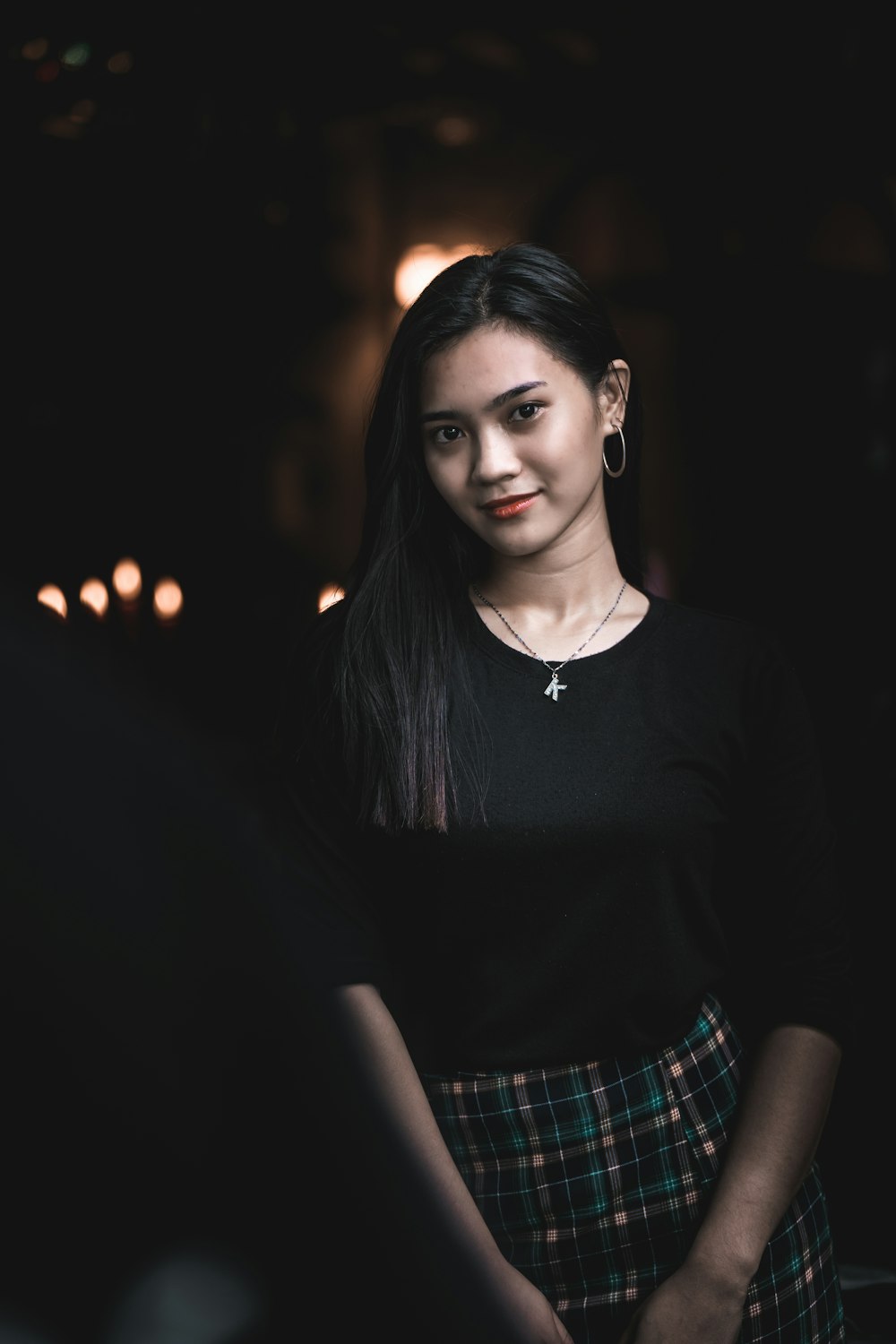 woman in black crew neck shirt and plaid skirt