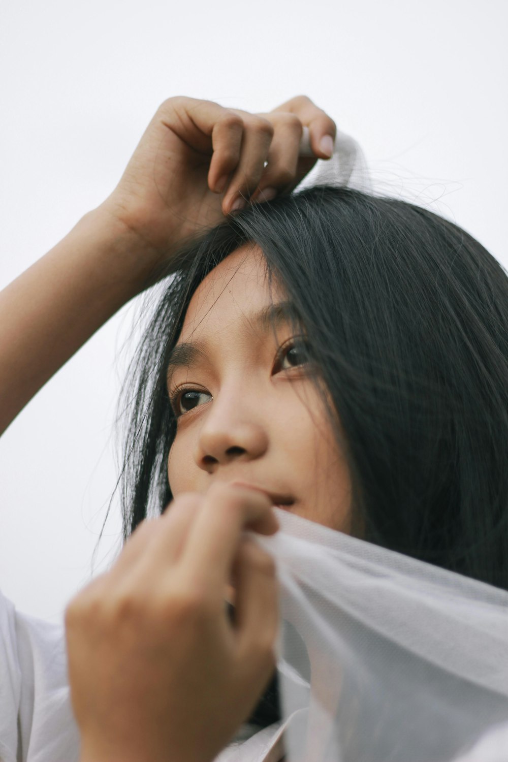 woman in white shirt holding her hair