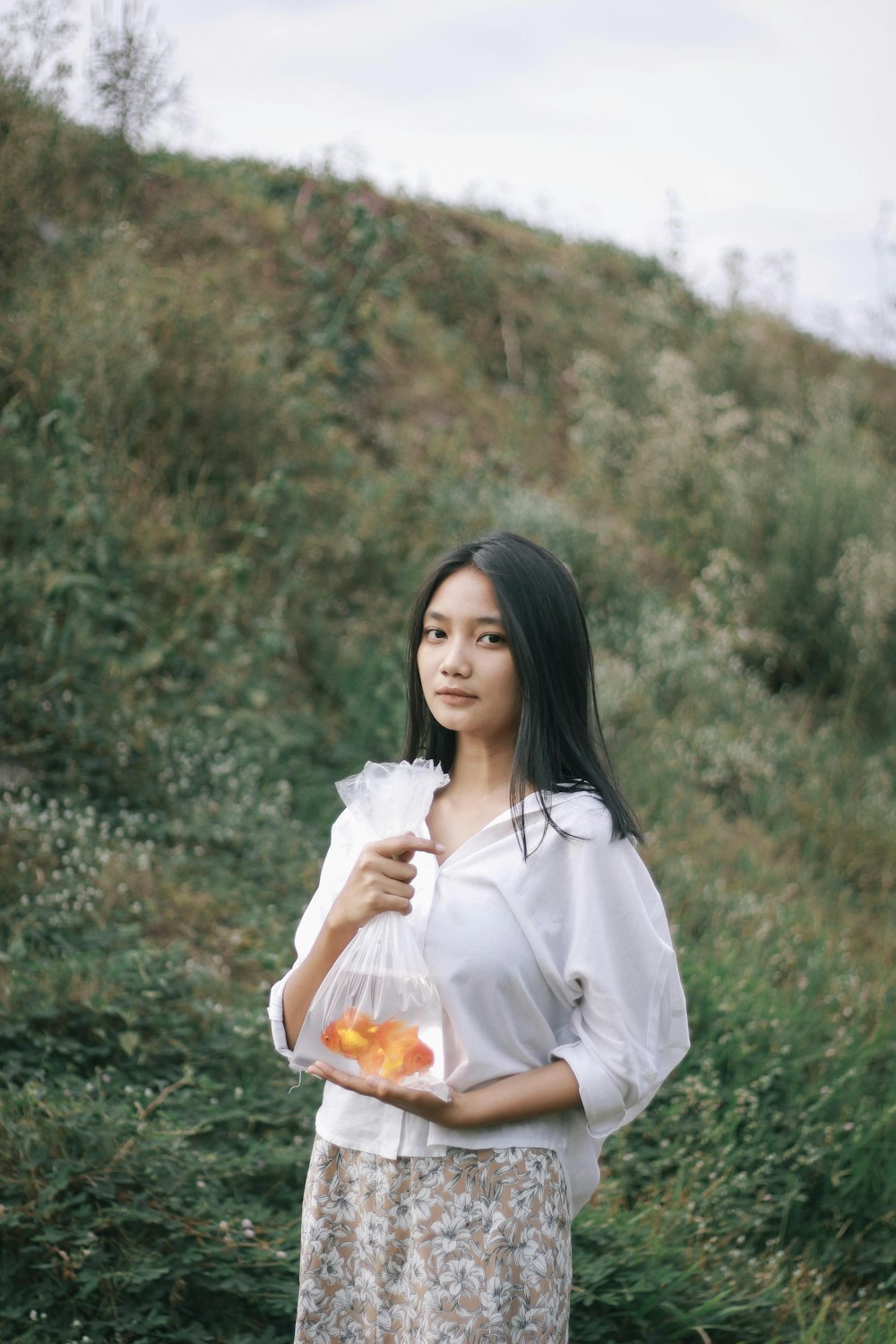 woman in white dress sitting on green grass during daytime