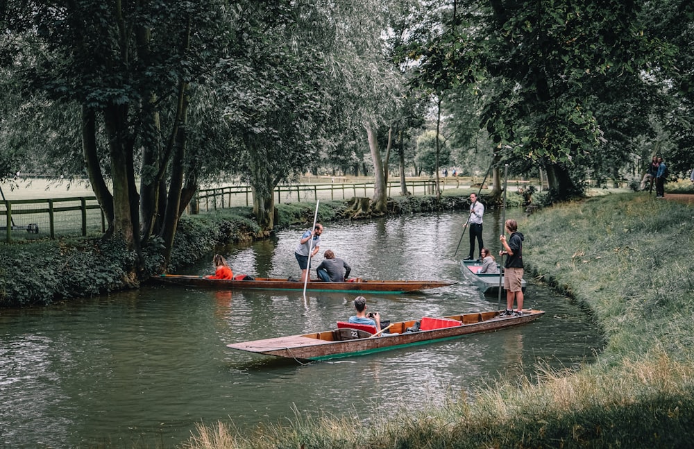 people riding on red boat on river during daytime