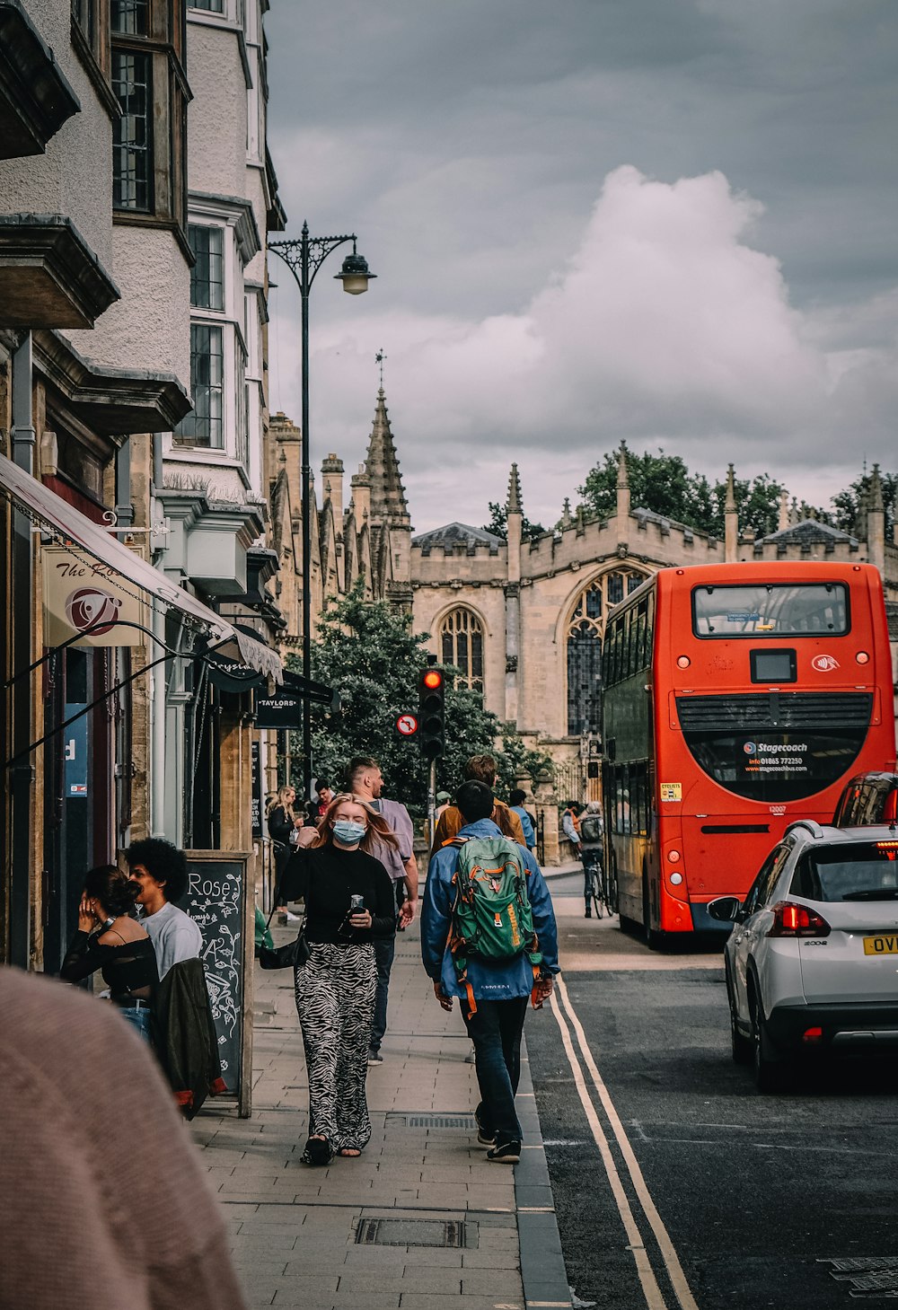 people walking on street near red bus during daytime