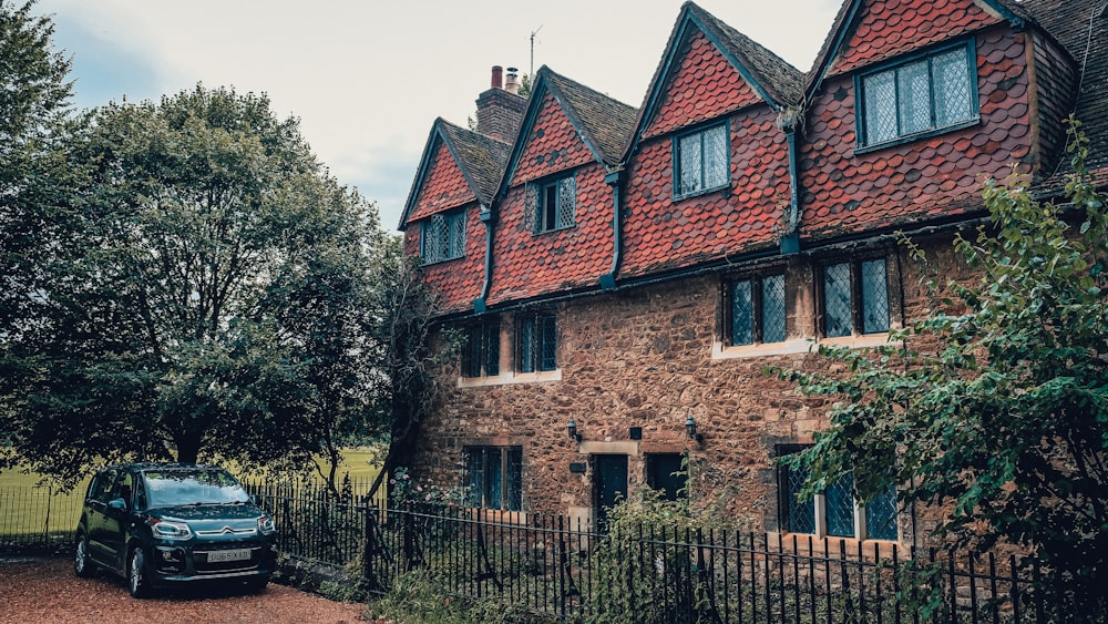 brown brick house surrounded by green trees during daytime