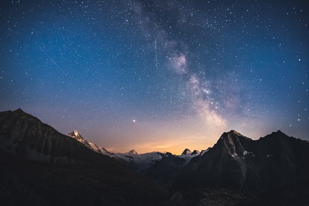 snow covered mountain under blue sky during night time