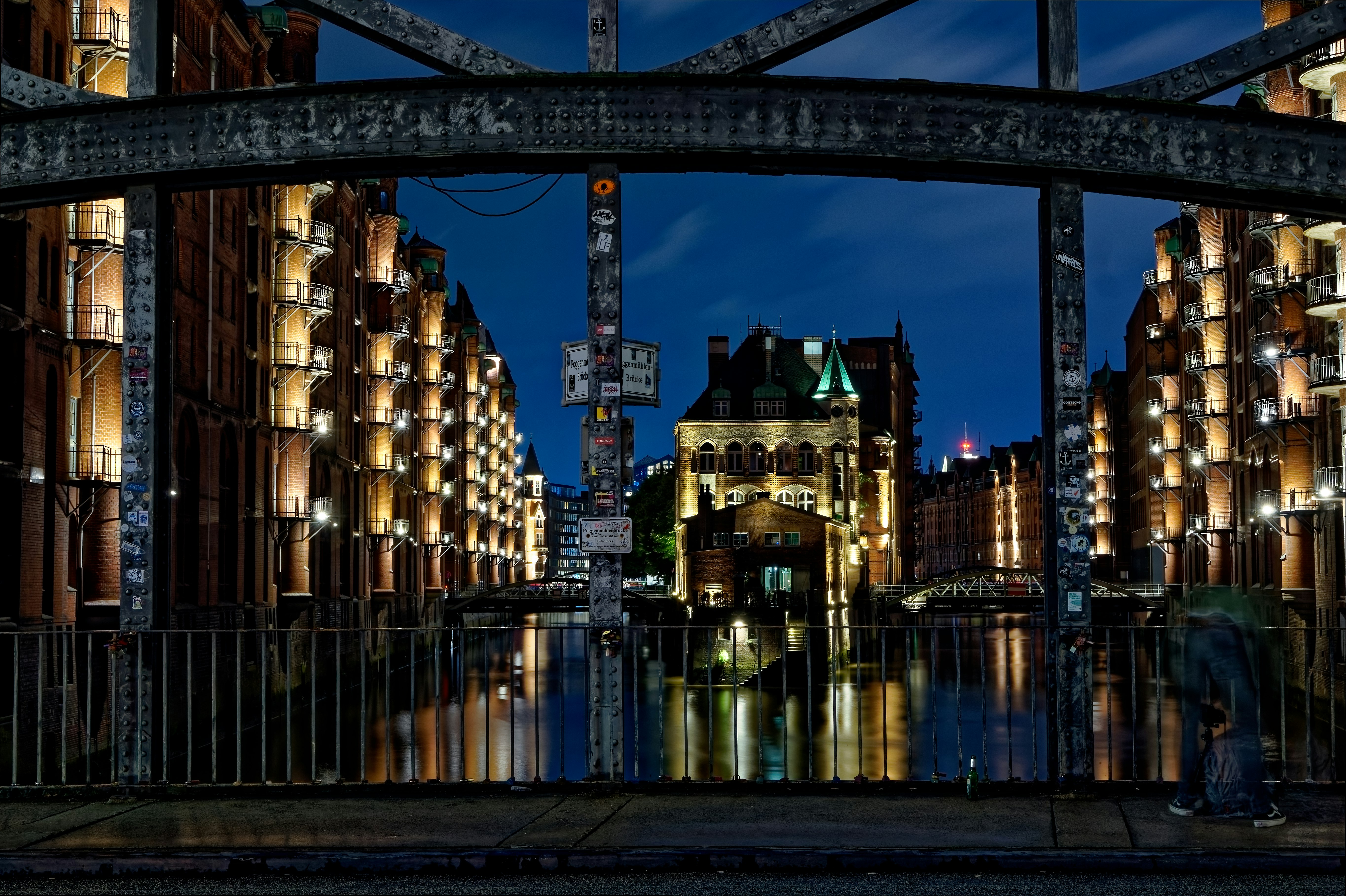 brown metal bridge across city buildings during night time