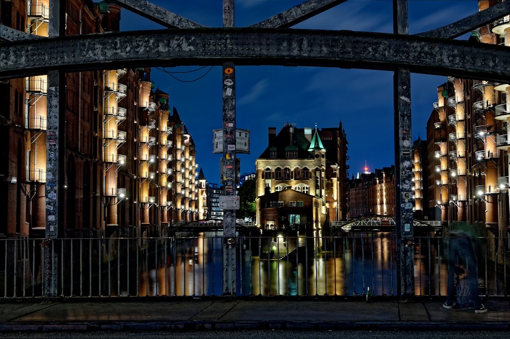 brown metal bridge across city buildings during night time