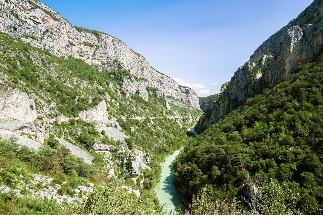 green and gray mountains beside river under blue sky during daytime