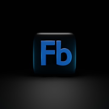 A dark background with a cube in the center, featuring the letters 'Fb' in bold, blue font. The cube appears to have a glossy finish, with reflections visible on its surface.