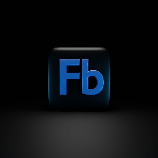 A dark background with a cube in the center, featuring the letters 'Fb' in bold, blue font. The cube appears to have a glossy finish, with reflections visible on its surface.