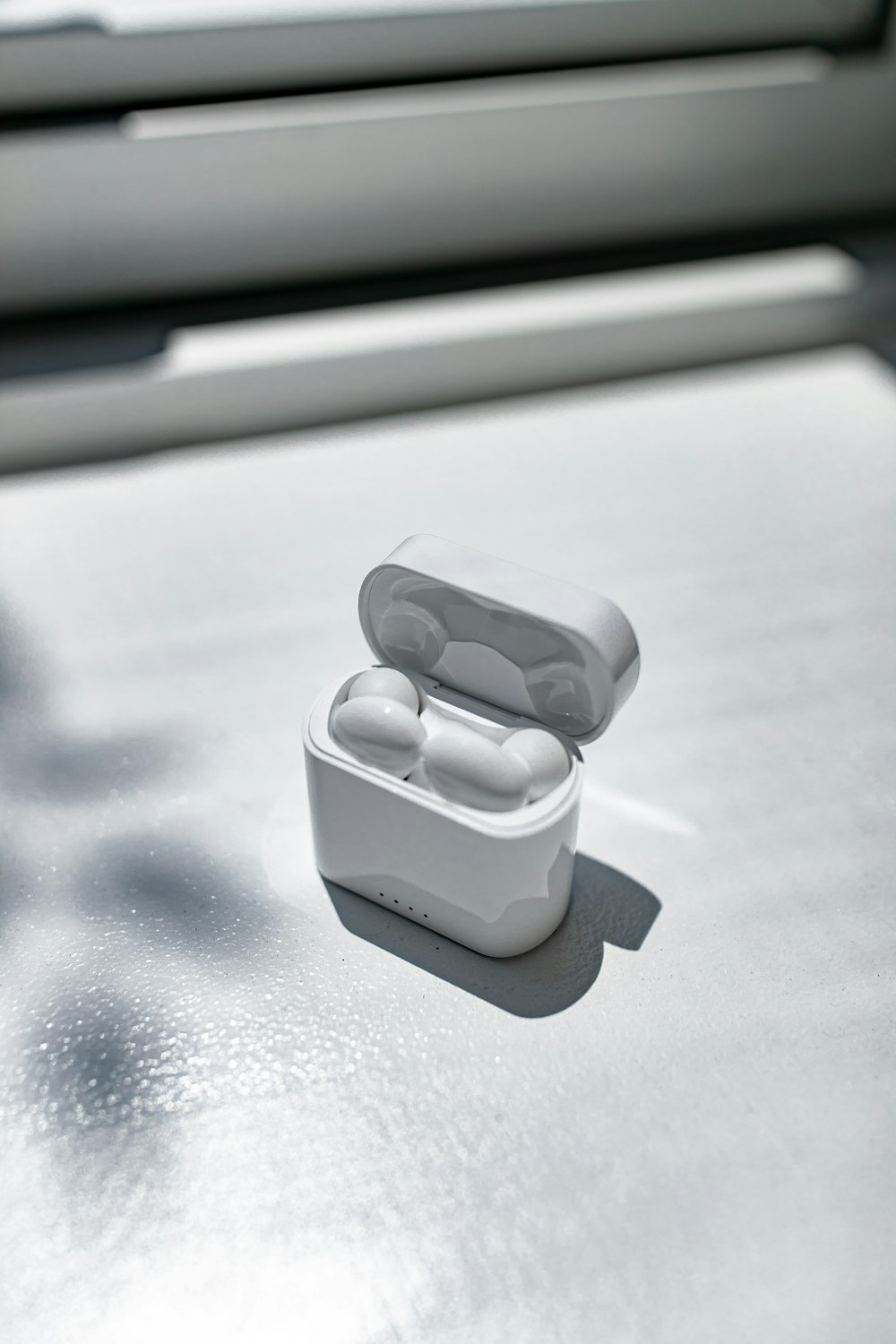 white apple earpods in white plastic case